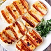 Grilled halloumi cheese served on a white plate.