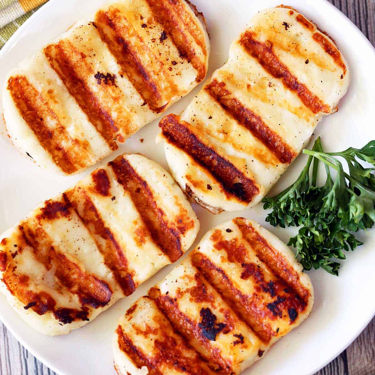 Grilled halloumi cheese served on a white plate.