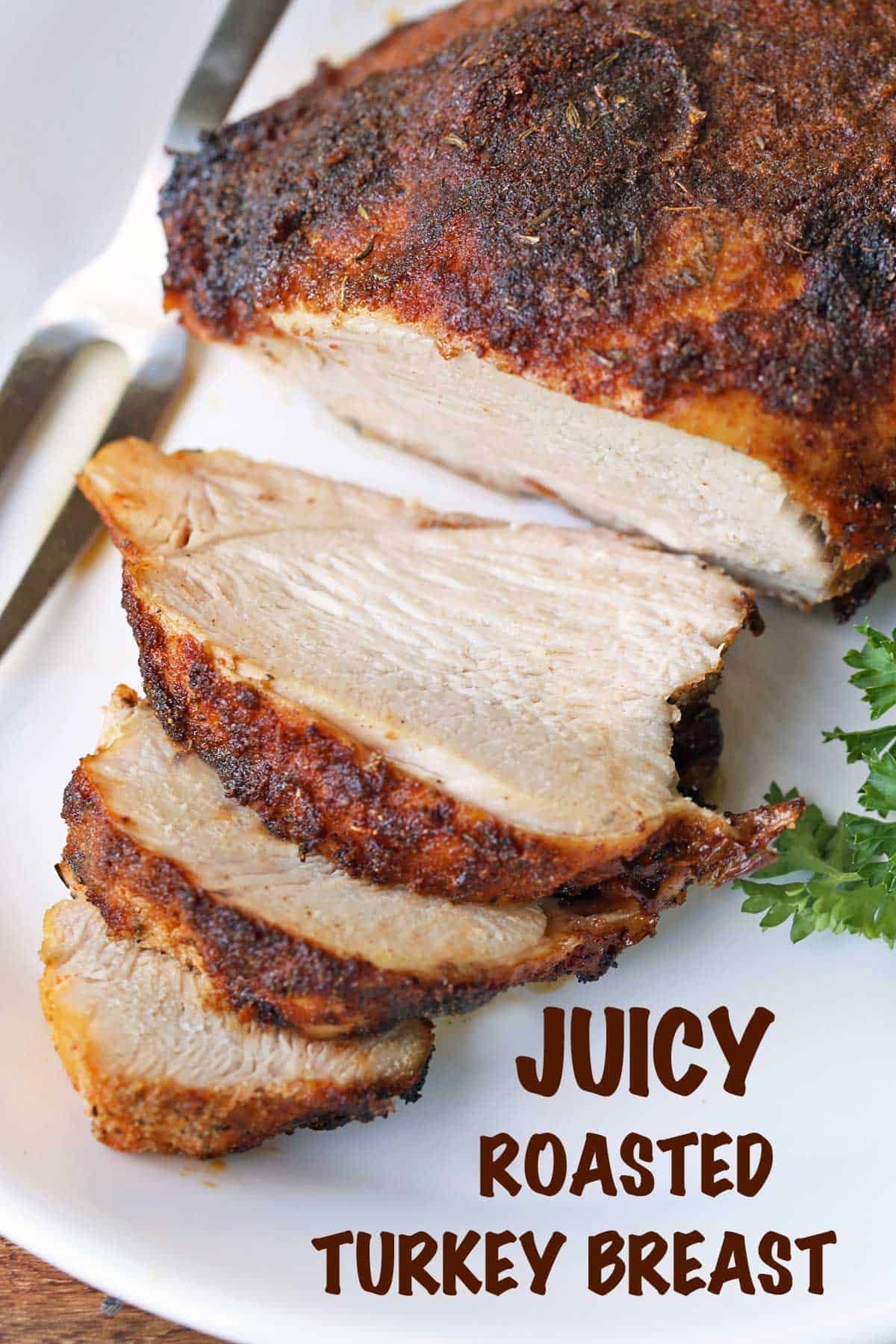 Roasted boneless turkey breast, sliced, served on a tray garnished with parsley. 