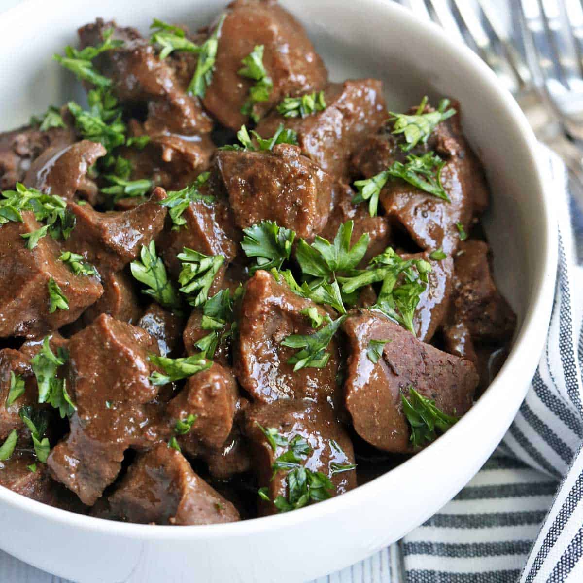 Beef heart stew served in a bowl with a napkin.