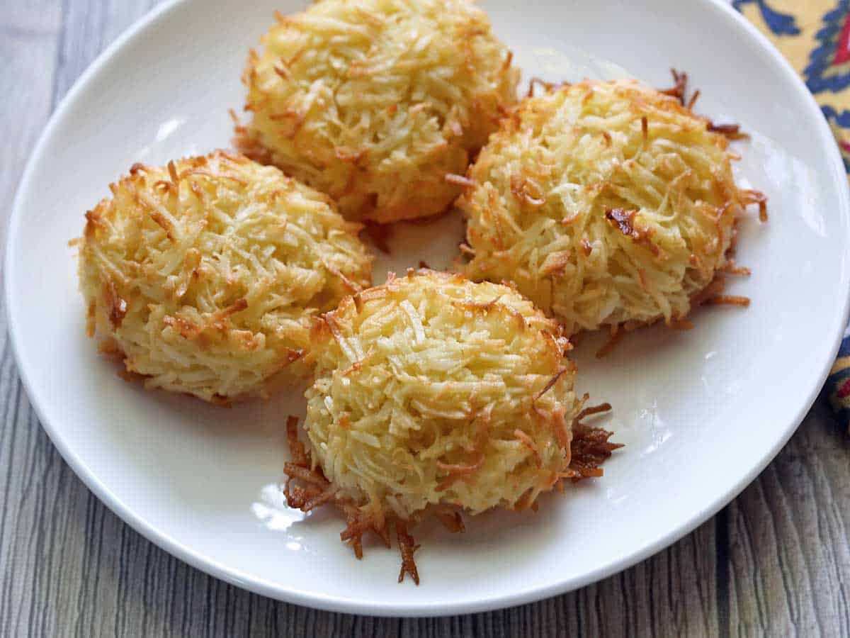 Four keto coconut macaroons served on a white plate. 