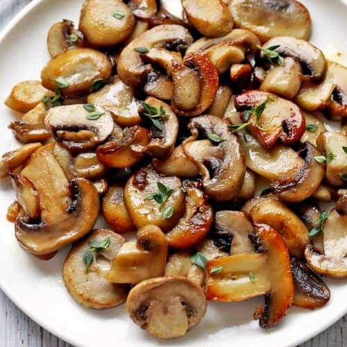 Sauteed mushrooms are topped with chopped parsley.