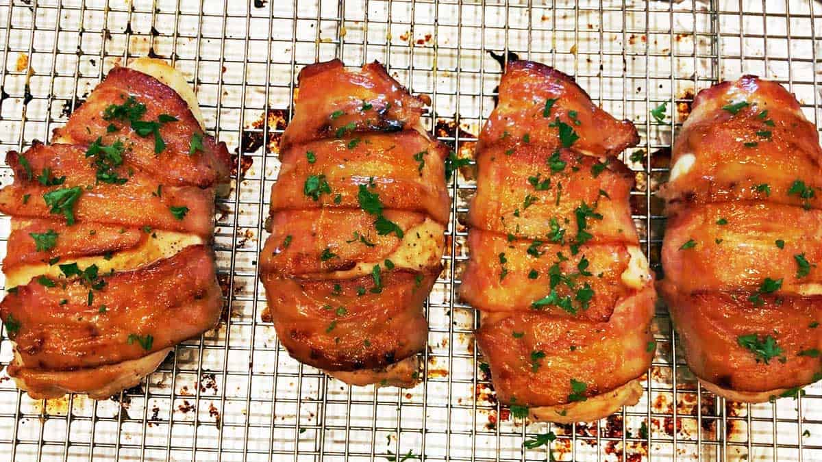 Baked bacon-wrapped chicken on a wire rack.  