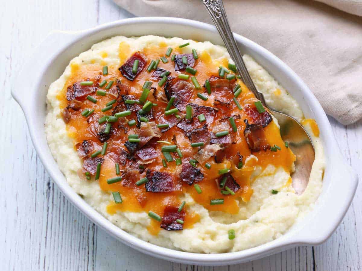 Loaded mashed cauliflower topped with cheese, bacon, and chive.