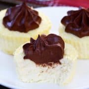 Keto mini cheesecakes with chocolate frosting served on a white plate.