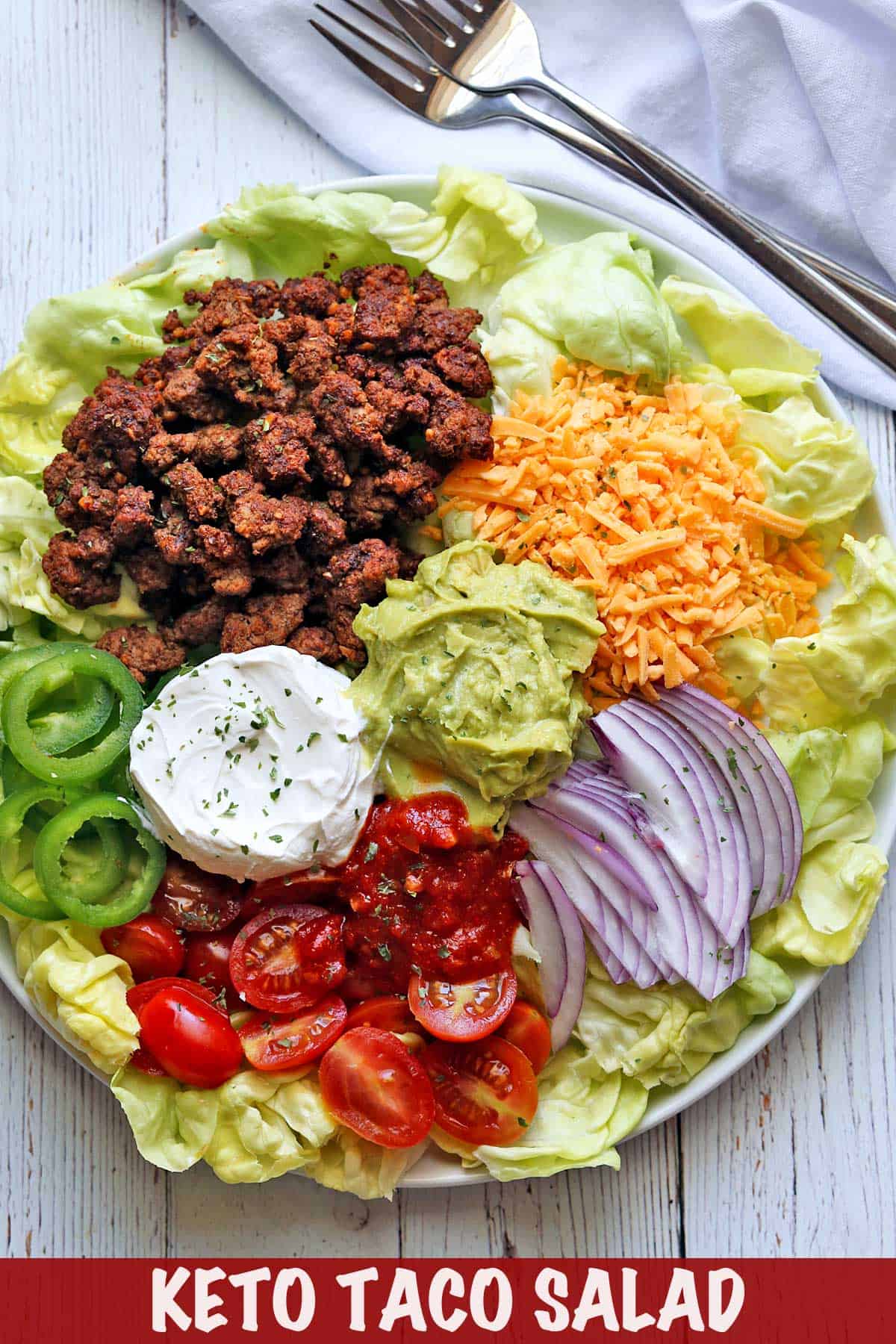 Taco salad with ground beef served on a white plate. 