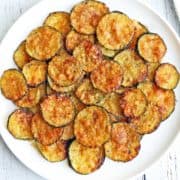 Zucchini chips served on a white plate.