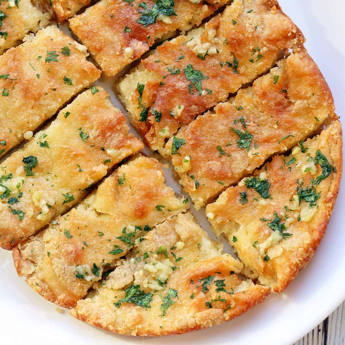 Keto garlic bread served on a white plate.