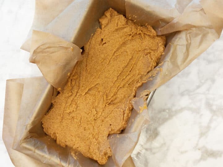 Keto pumpkin bread batter in a pan lined with parchment paper.