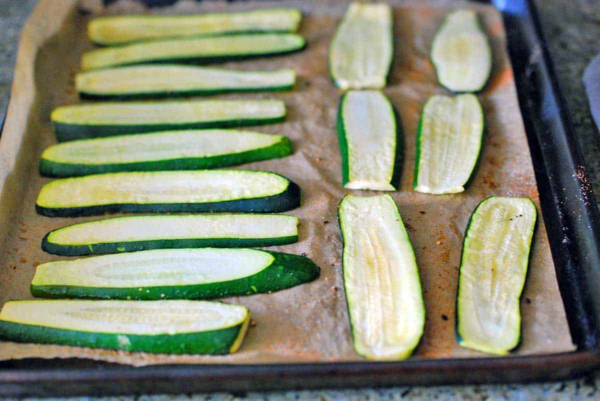 Zucchini slices arranged  on a baking sheet. 