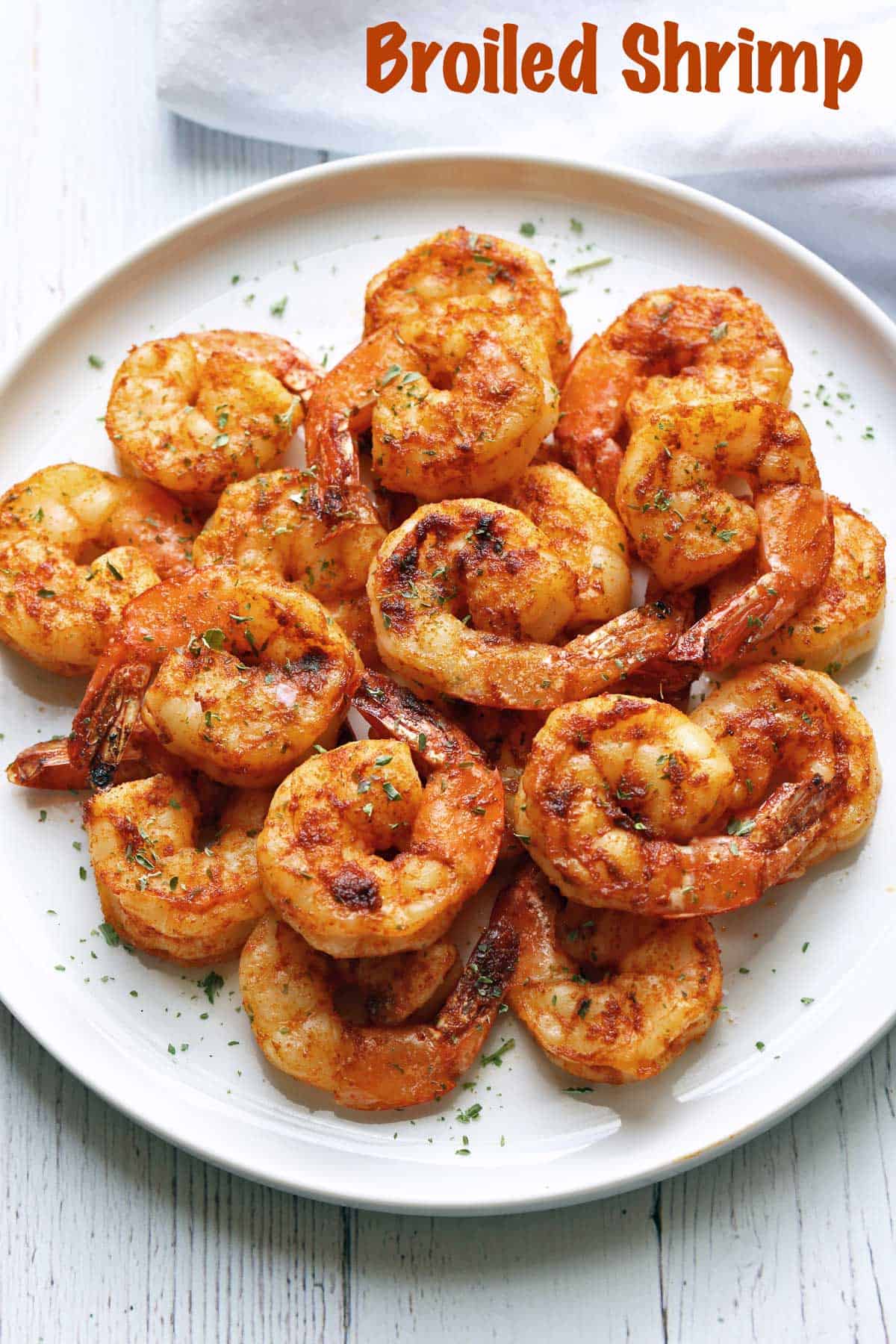 Broiled shrimp with cajun seasoning, served on a white plate.