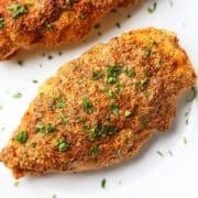 Parmesan-crusted chicken topped with chopped parsley.