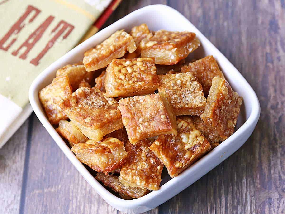 Pork skin chips served in a white bowl. 