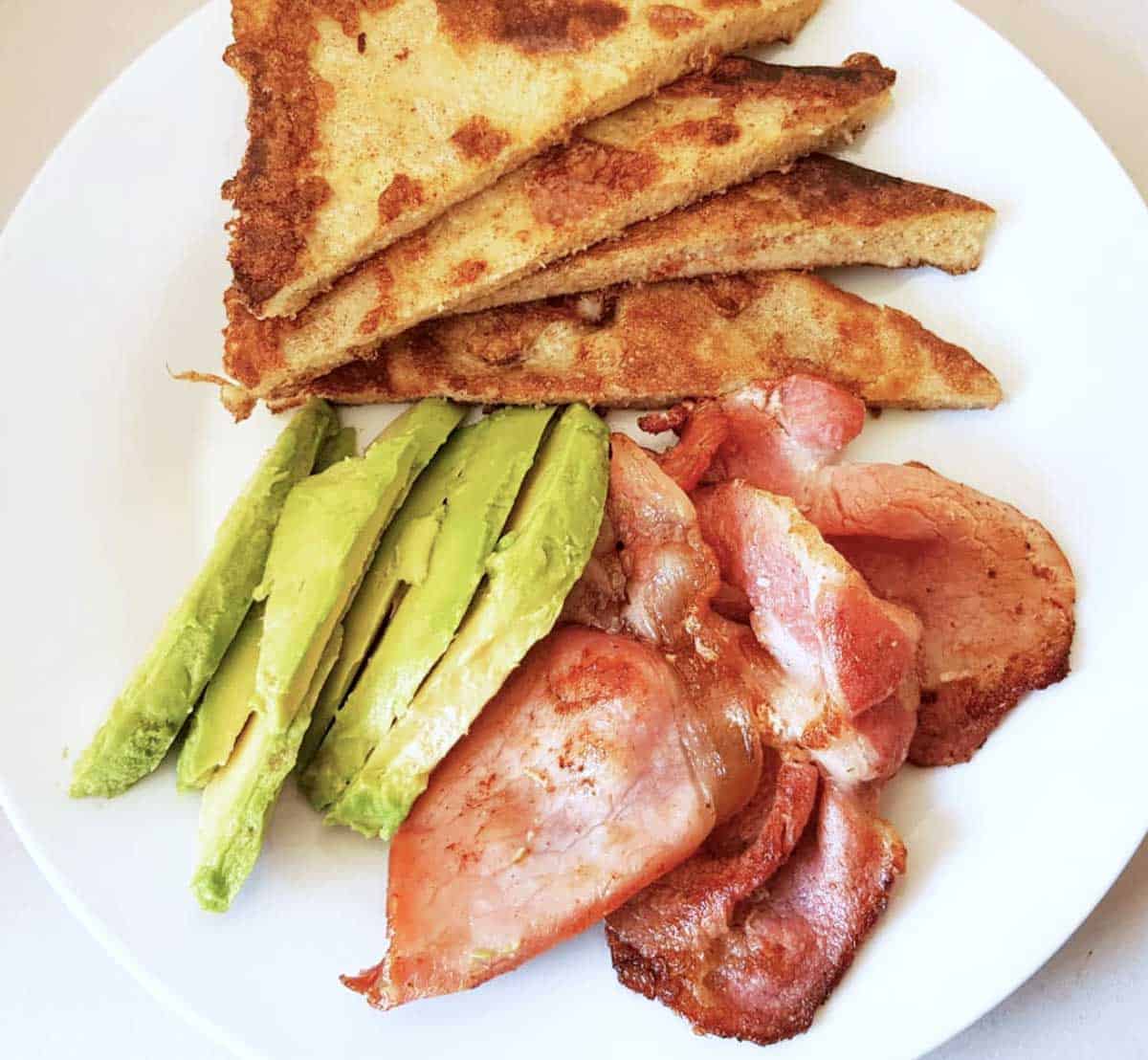 Keto French toast served with bacon and avocado.