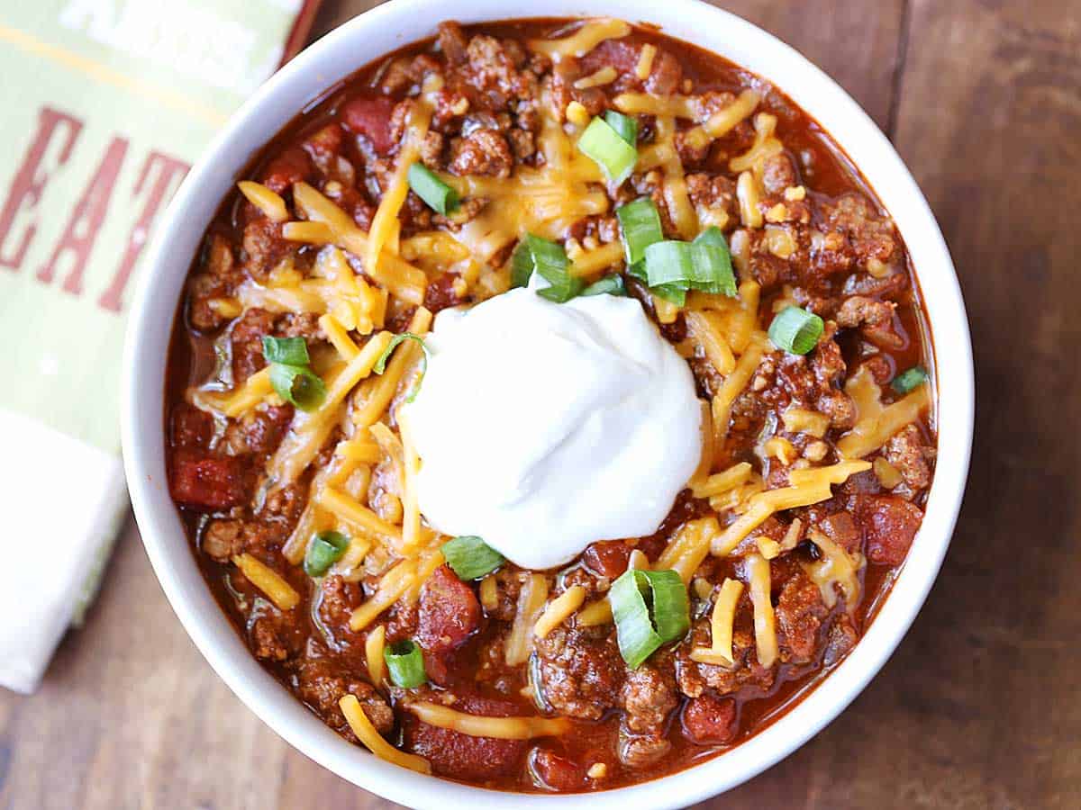 Chili without beans, served in a bowl, topped with sour cream.