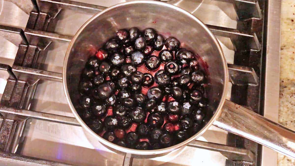 Blueberry compote cooking in a saucepan. 