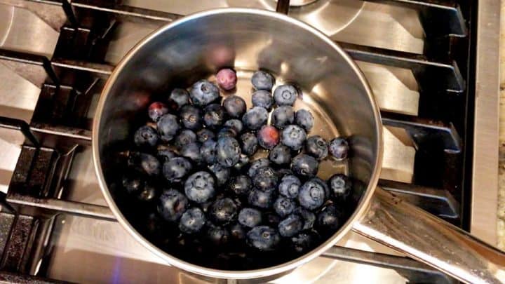 Adding blueberries, water, lemon juice, and a sweetener to a small saucepan.