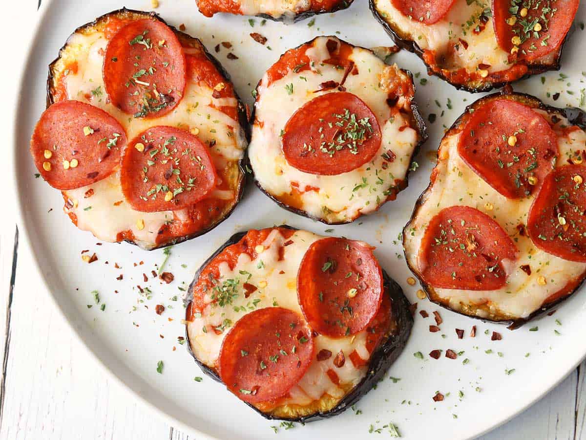 Eggplant pizza bites served on a white plate. 