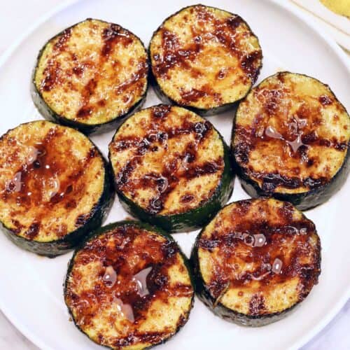Grilled zucchini served on a white plate.