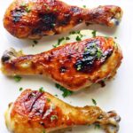 Honey garlic chicken is topped with parsley.