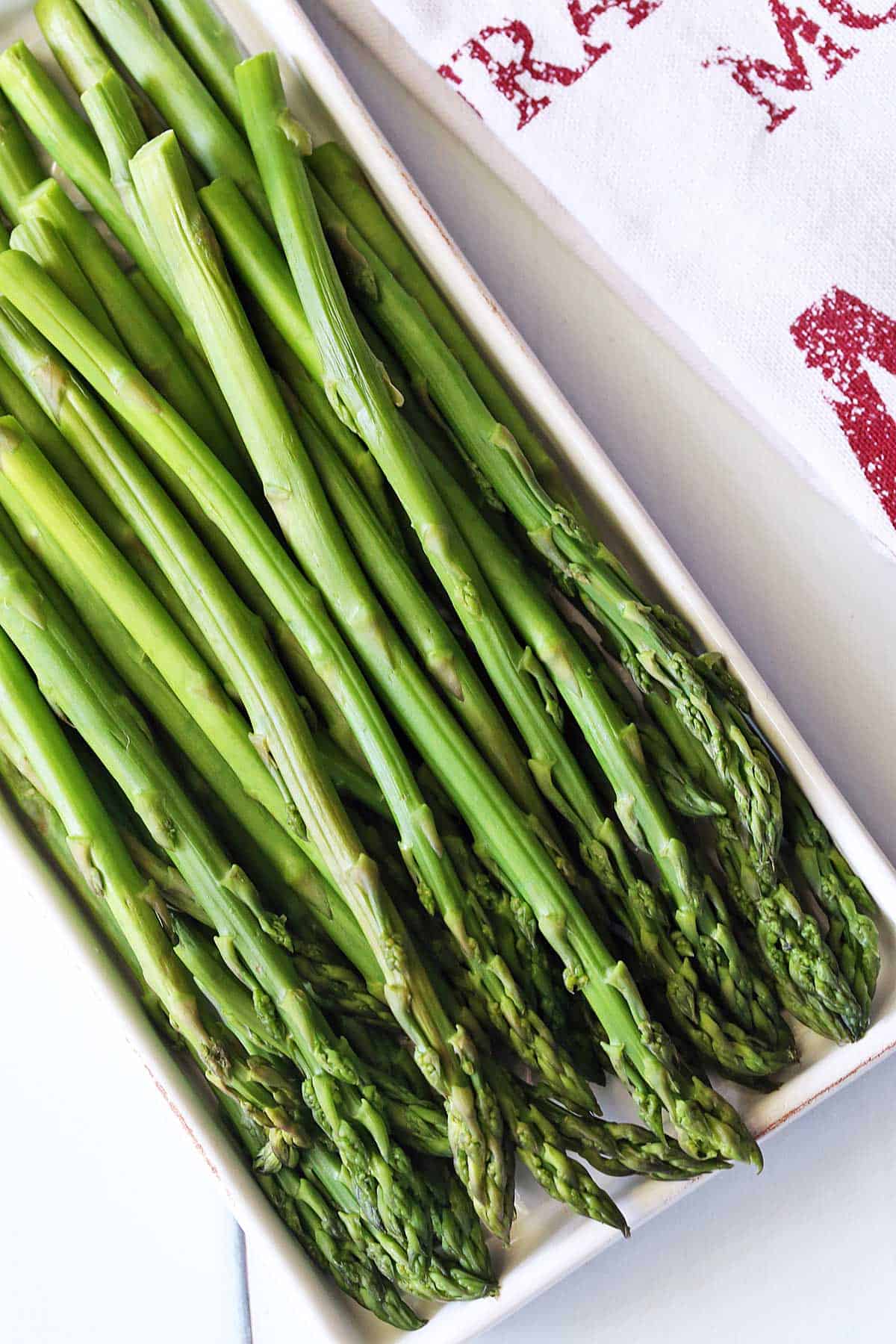 Microwave asparagus served on a white tray. 