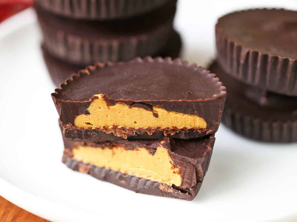 Keto peanut butter cups stacked on a white plate. 