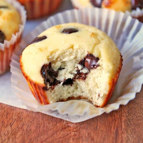 Protein muffins with chocolate chips are served on a wooden board.