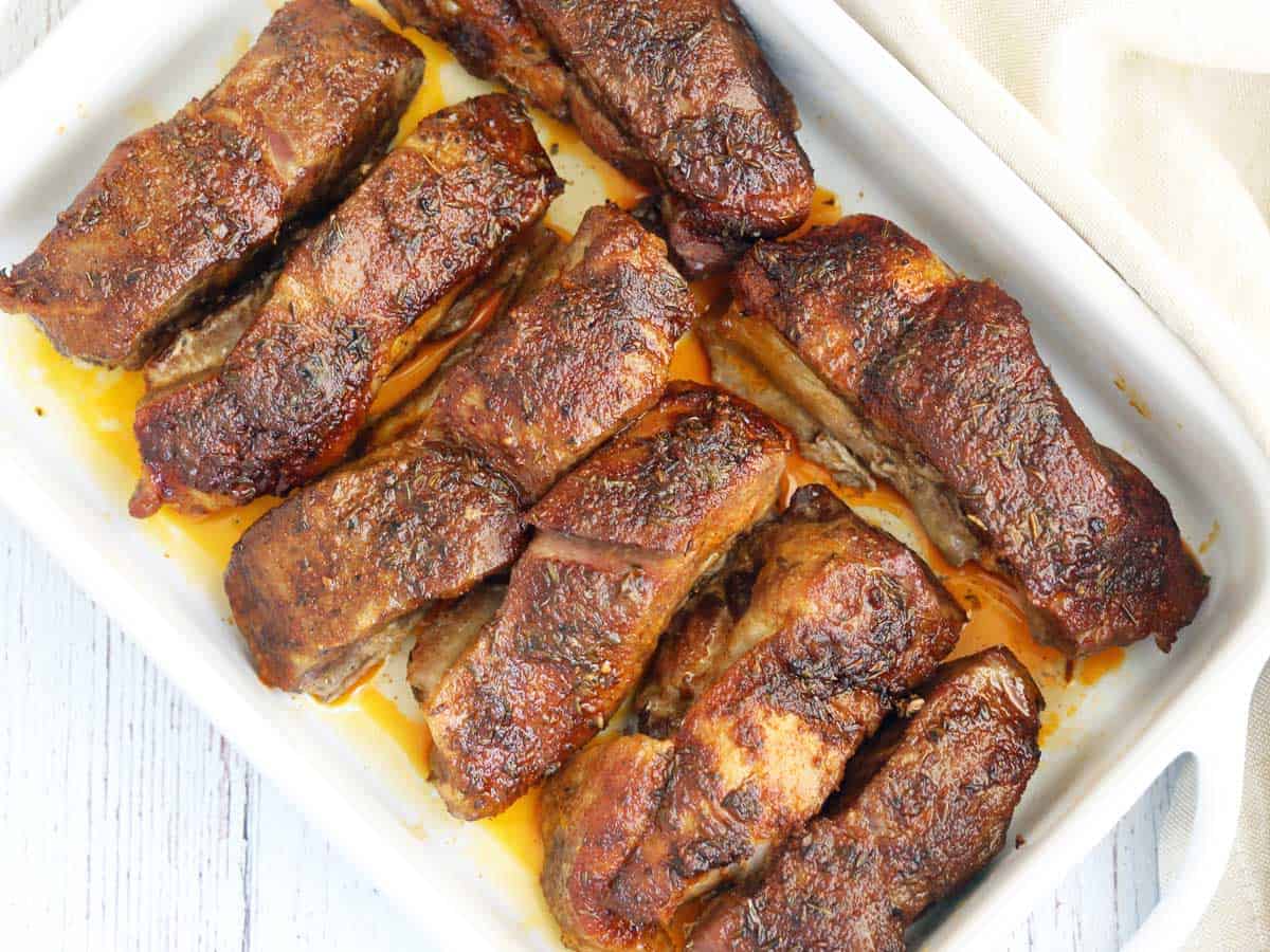 Country-style ribs served in a white baking dish. 