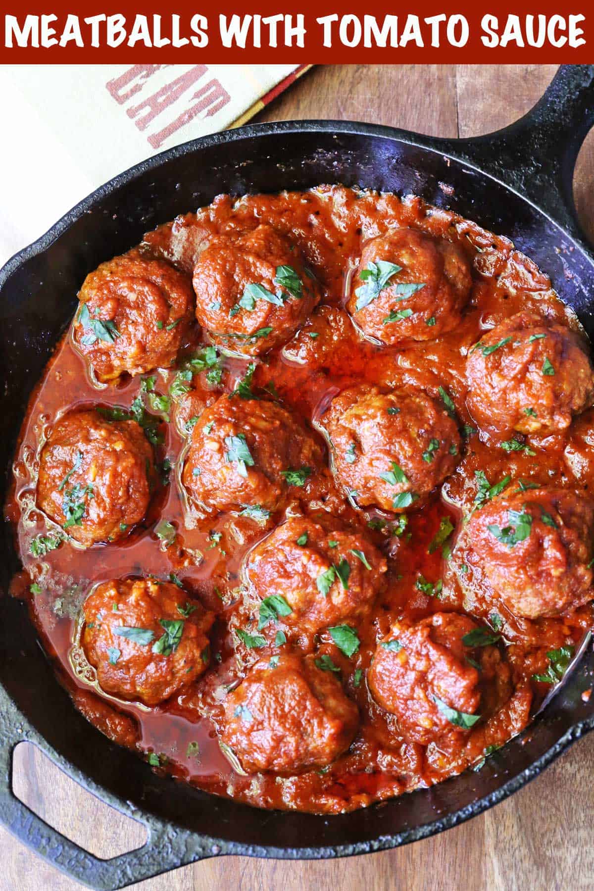 Meatballs in tomato sauce served in a cast-iron skillet with a napkin.  