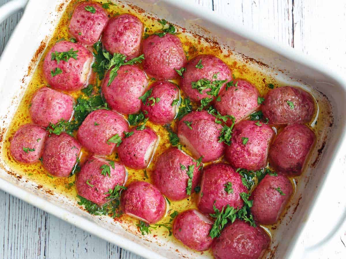 Roasted radishes served in a white baking dish. 