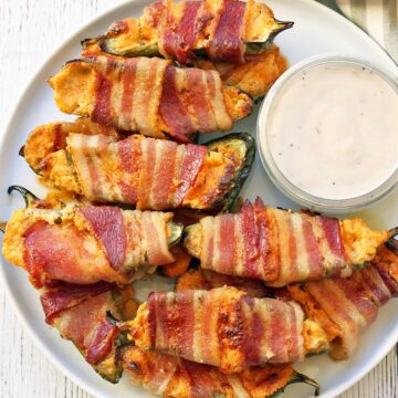 Jalapeno poppers piled on a white plate.