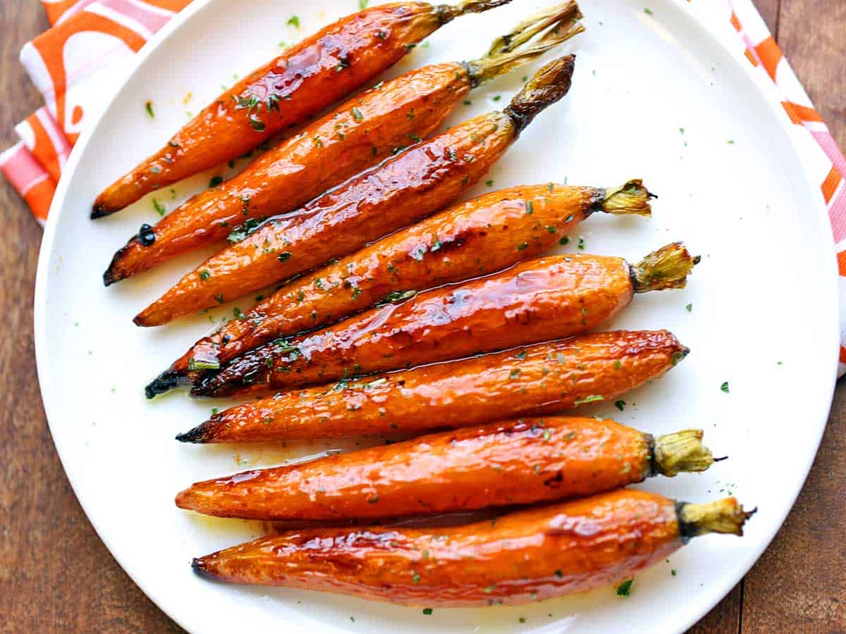 Oven-roasted carrots served on a white plate. 