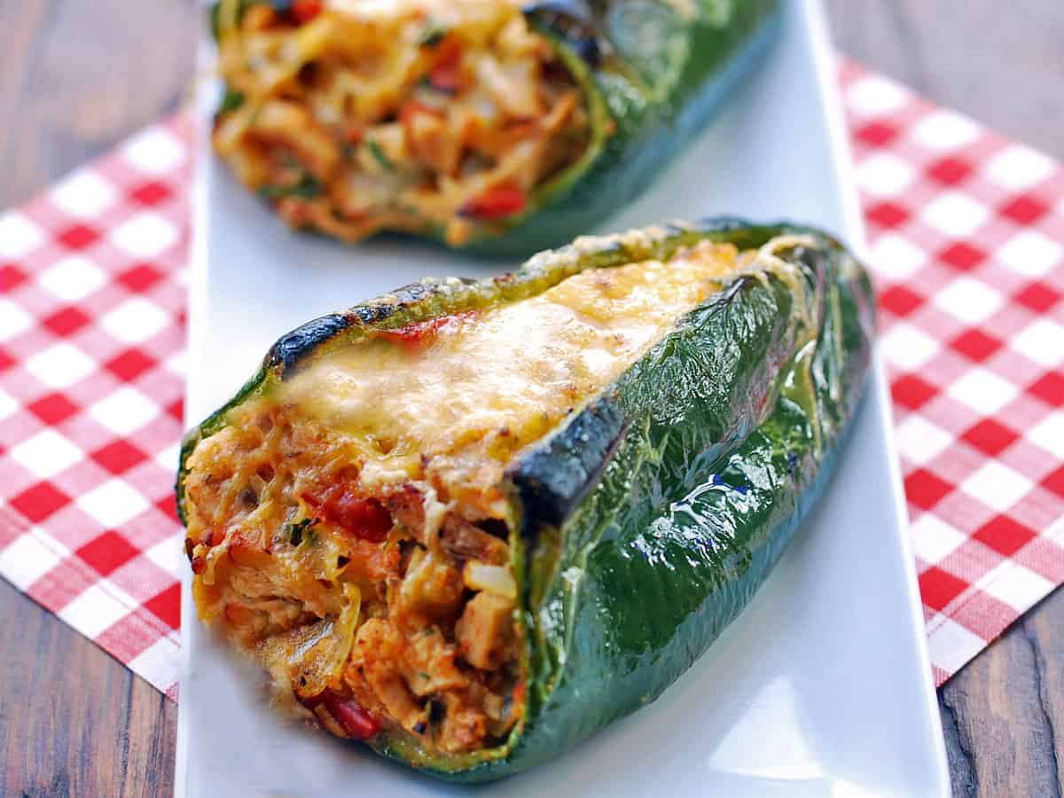 Stuffed poblano peppers served on a white plate.