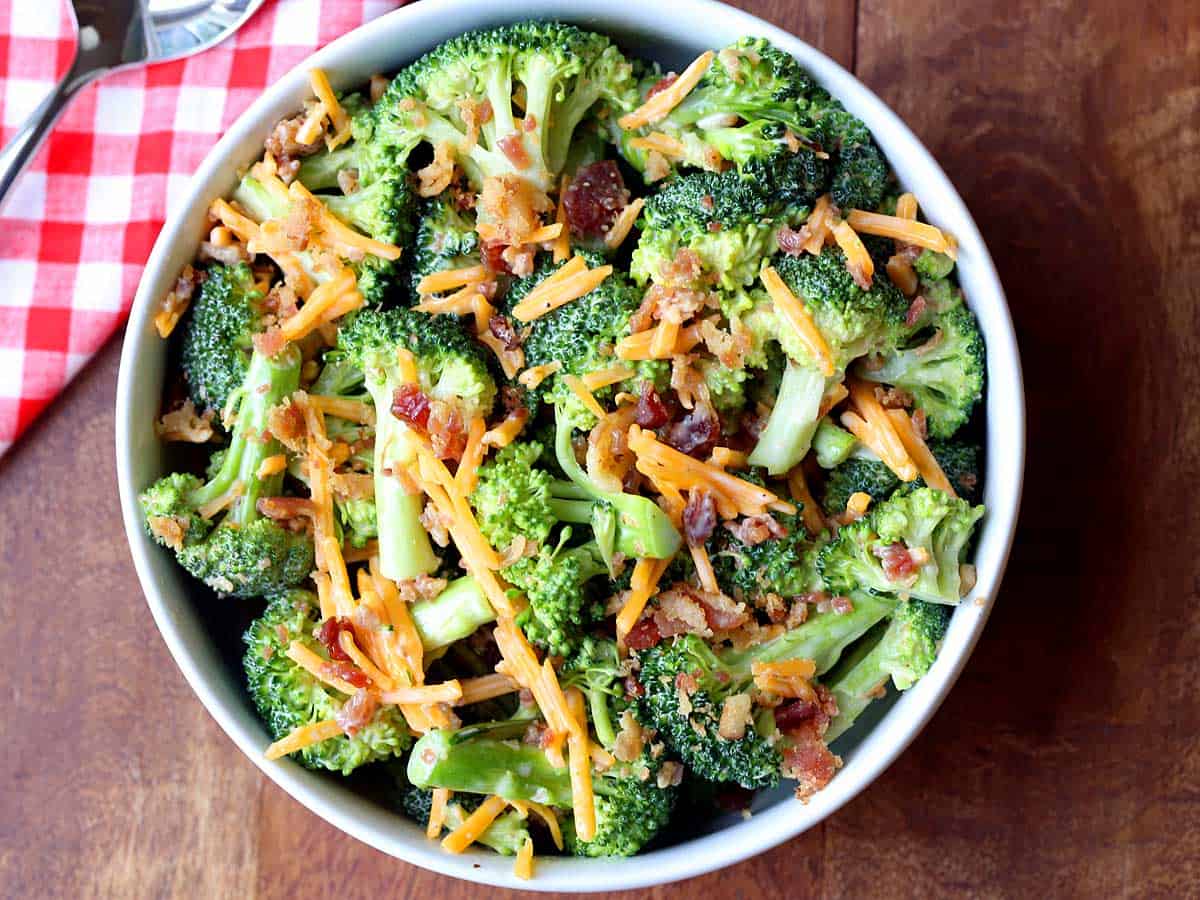Broccoli salad with bacon and cheese served in a white bowl. 