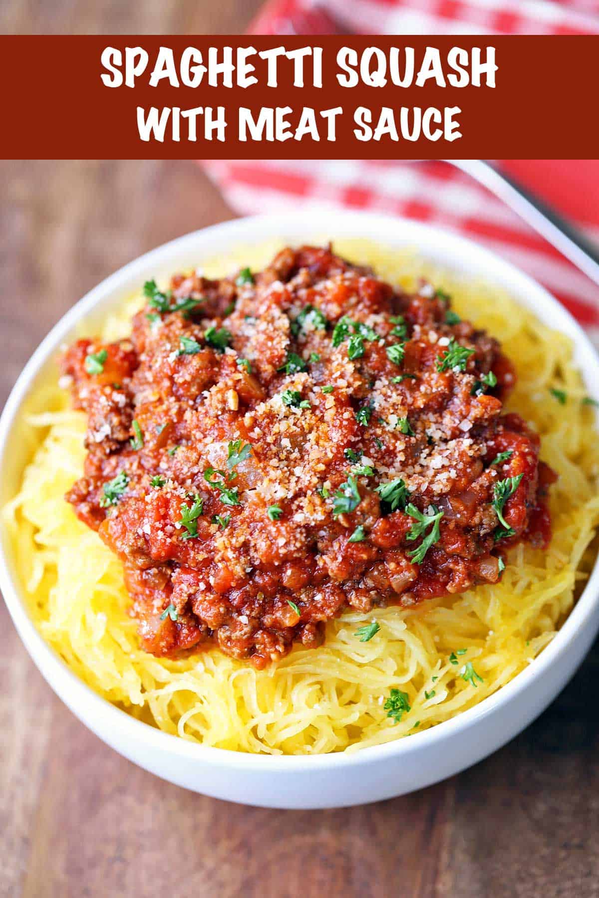 Spaghetti squash topped with meat sauce and served in a white bowl. 
