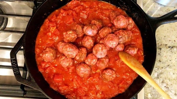 Adding the meatballs to the sauce.