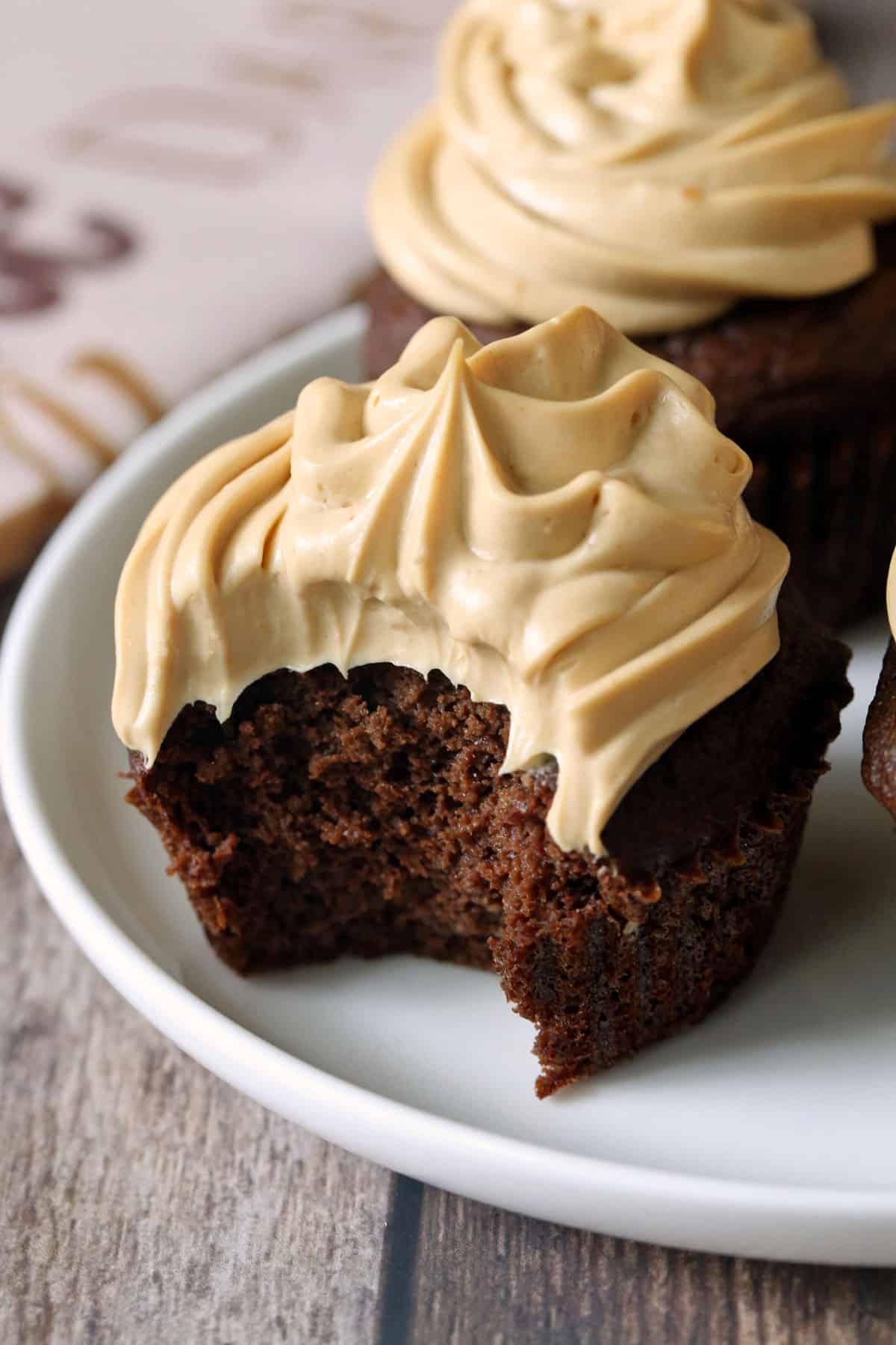 Keto chocolate cupcakes with a bite taken out of one cupcake. 