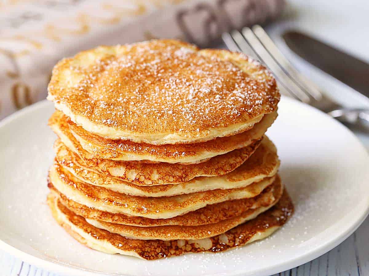 A stack of protein pancakes served on a white plate. 