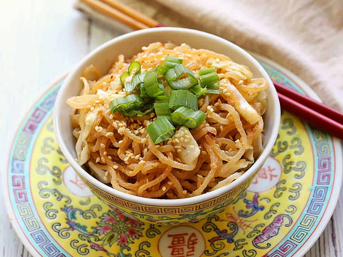 Shirataki sesame noodles served in an Asian-style bowl with chopsticks.