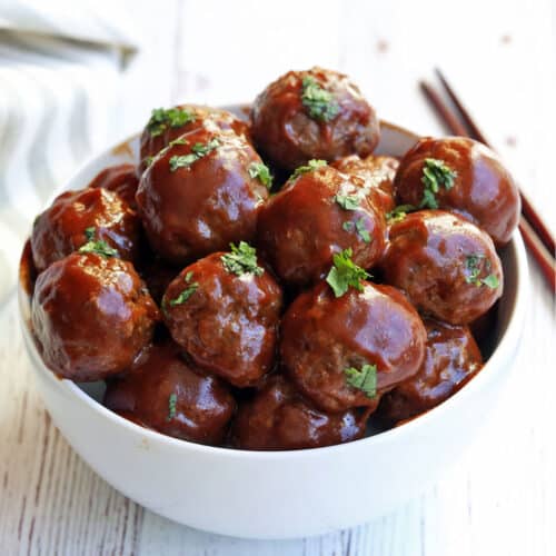 Sweet and sour meatballs served with chopsticks.