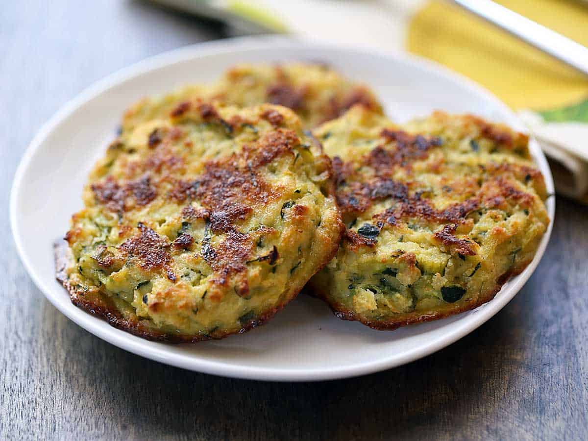 Zucchini fritters served on a white plate. 