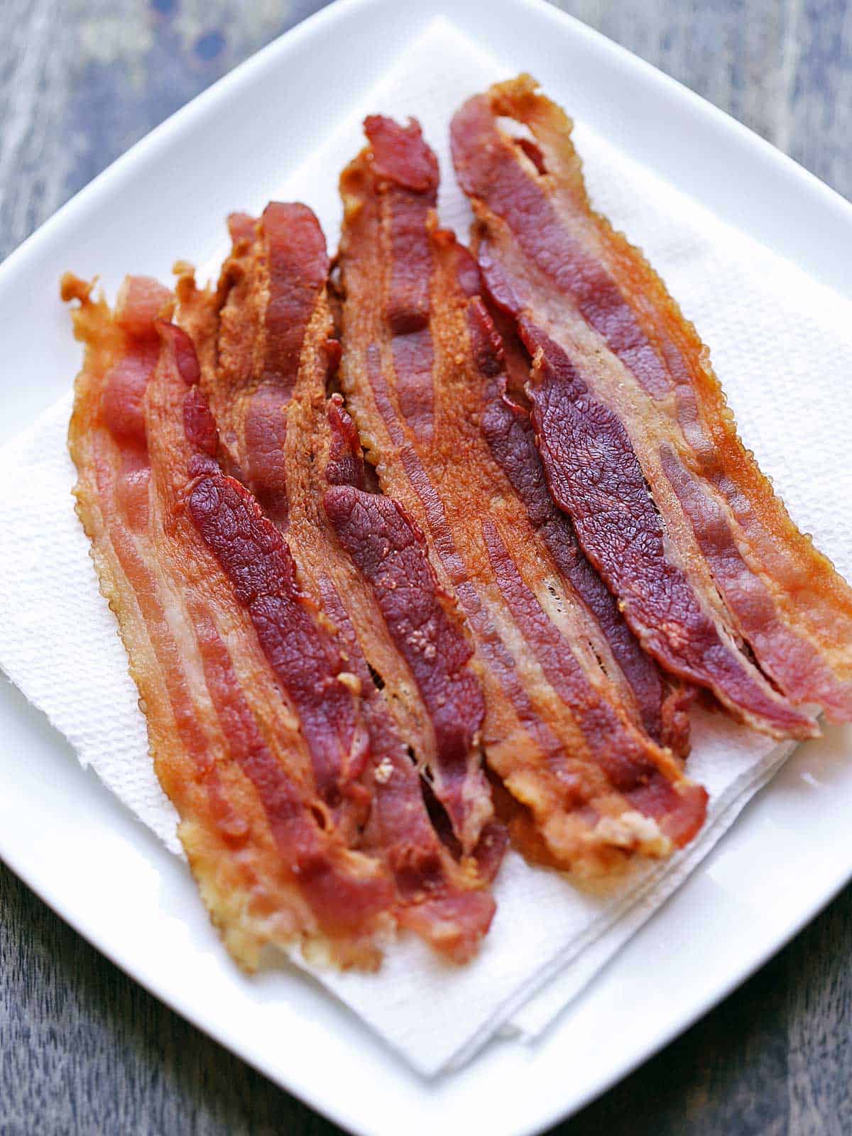Strips of microwave bacon served on a paper-towel-lined plate. 