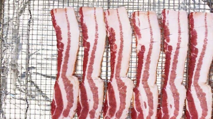 Bacon slices arranged on a wire rack.