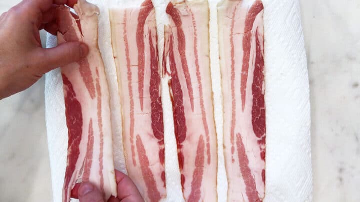 Placing four bacon slices on paper towels.
