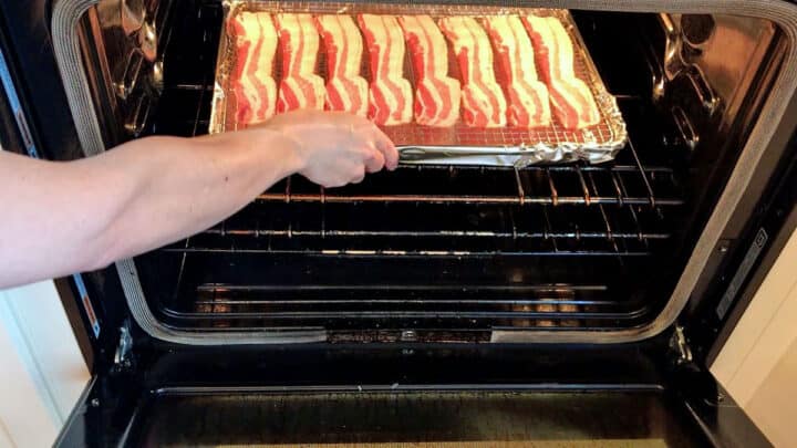 Placing the pan with the bacon in the oven.