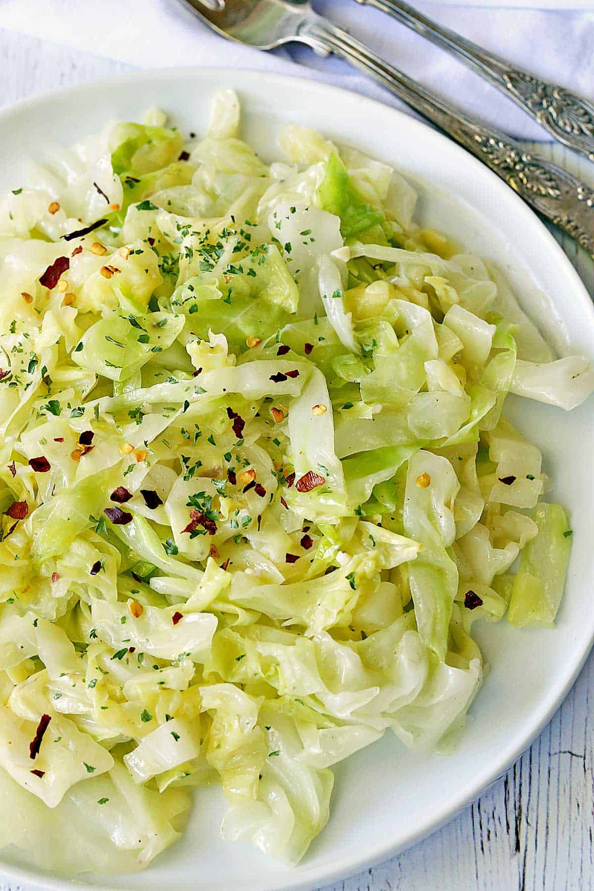 Steamed cabbage served on a white plate. 
