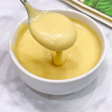 Blender hollandaise sauce served with a spoon.