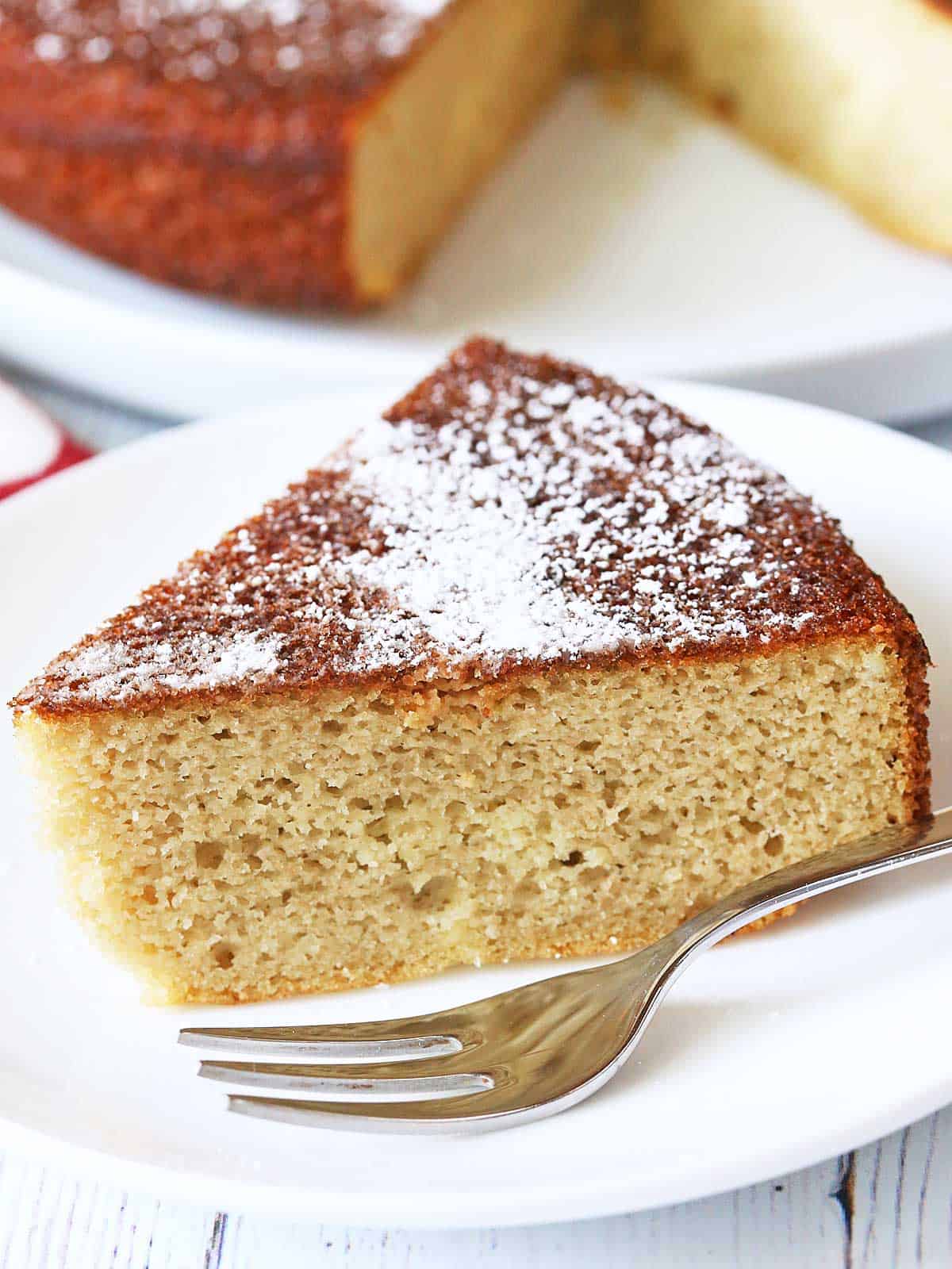 Almond flour cake served on a white plate with a fork. 