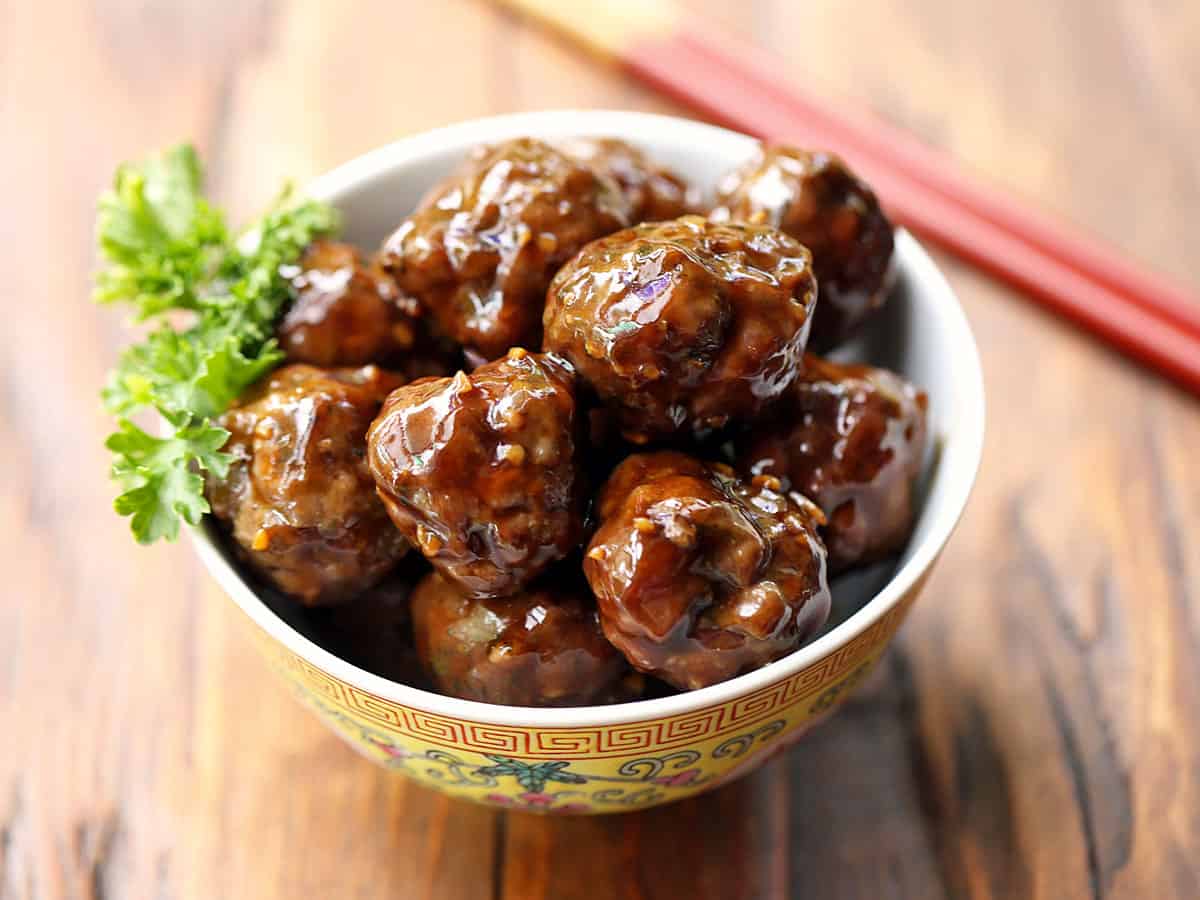 Asian meatballs served in a Chinese bowl with chopsticks. 