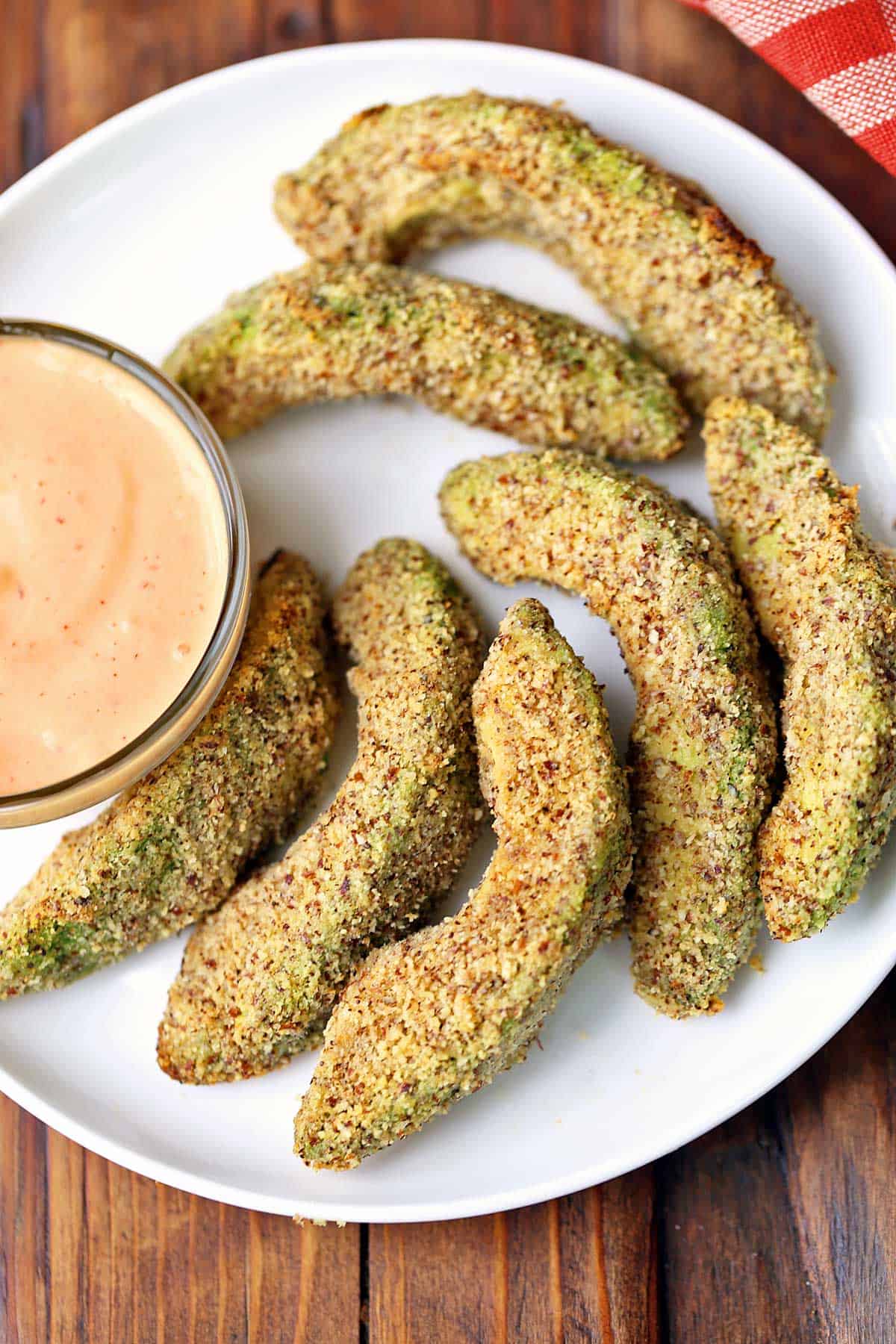 Avocado fries served on a white plate with chipotle dip. 